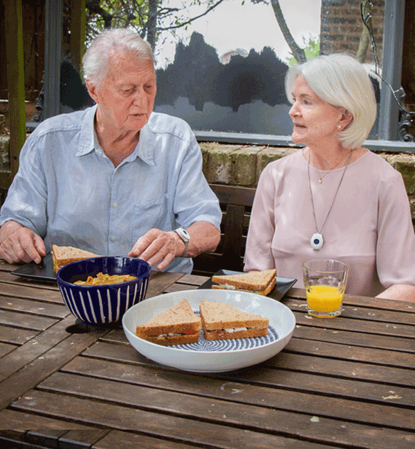 Elderly couple wearing digital fall alarms