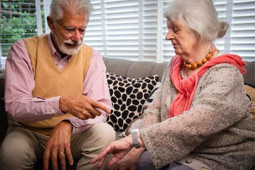 Elderly couple looking at a personal alarm